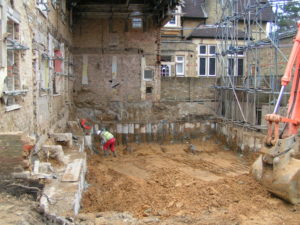 Excavation with pile beam underpinning.